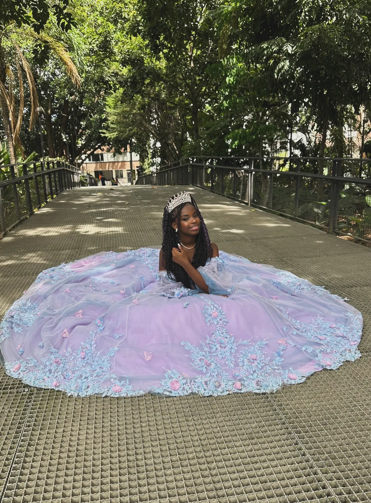 Luciana con su vestido de quince años, azul y rosa, en medio de un jardín